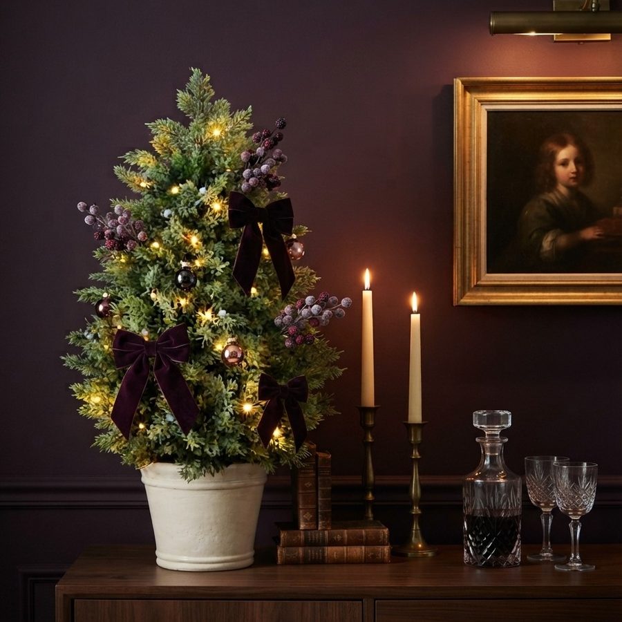 The tree styled with deep velvet bows against a plum wall